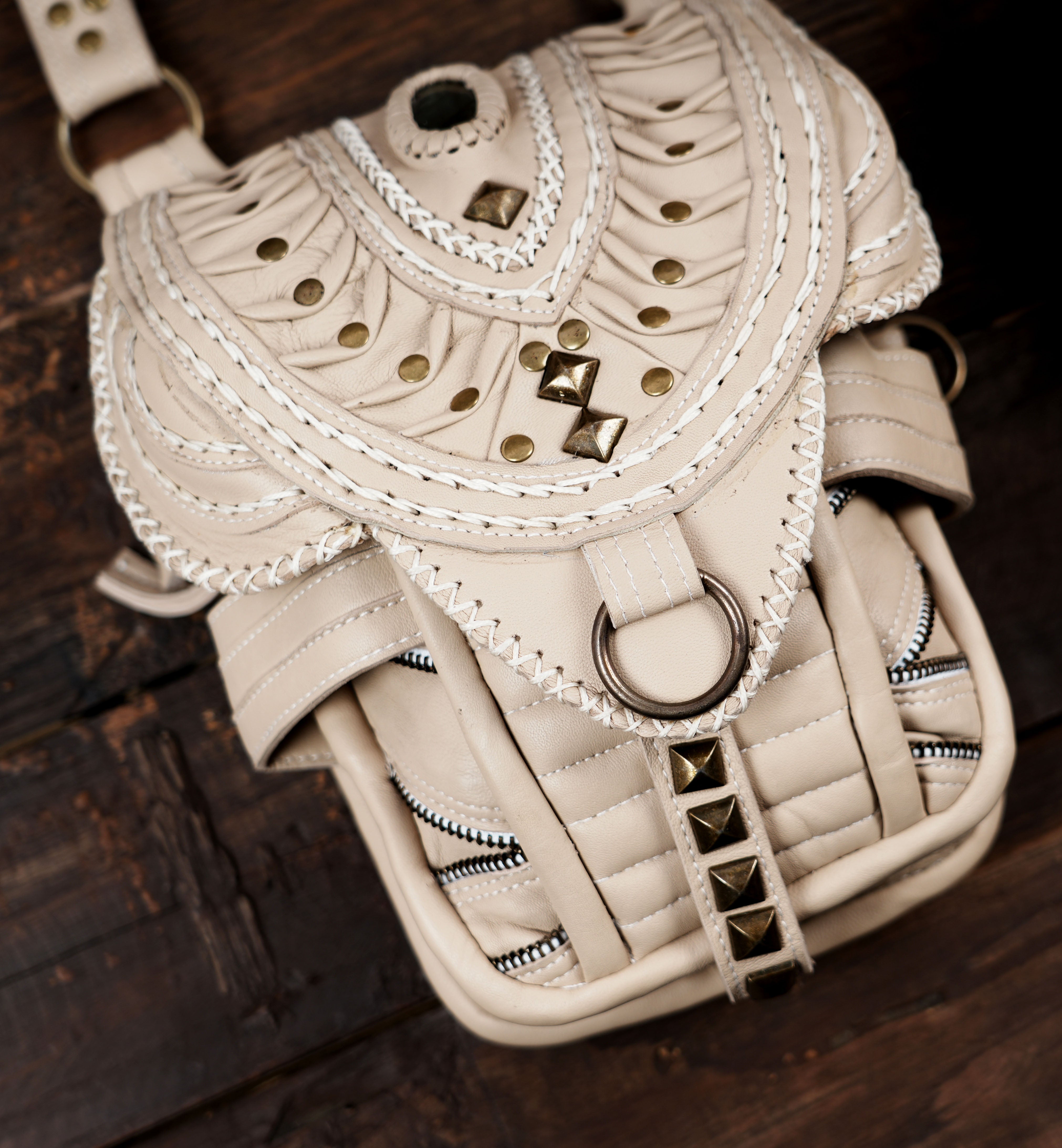 Functional dual pocket cream leather shoulder holster bag with secure zippered compartments.