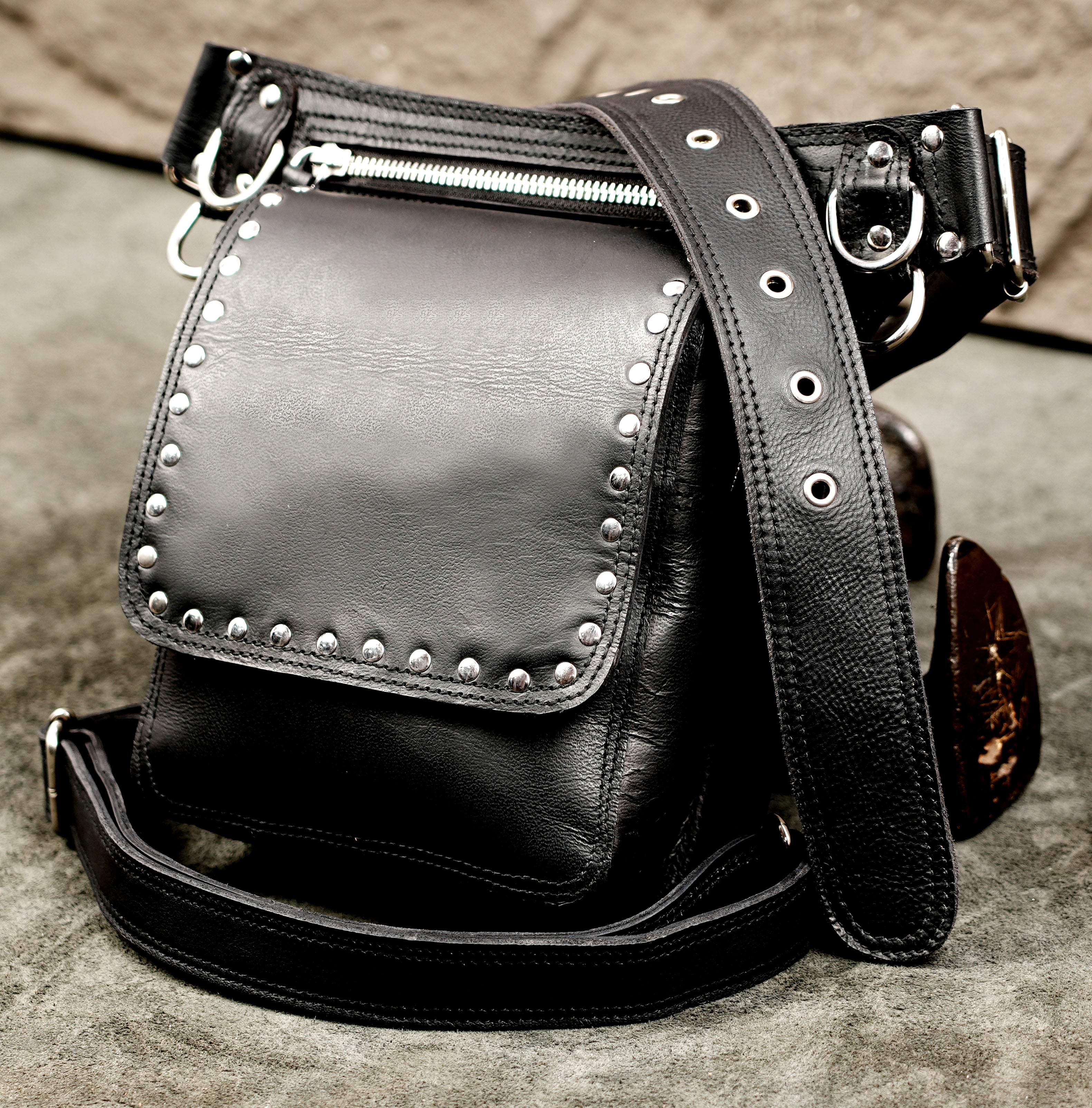 Heavy-duty black leather hip pouch with lower thigh stabilization strap.