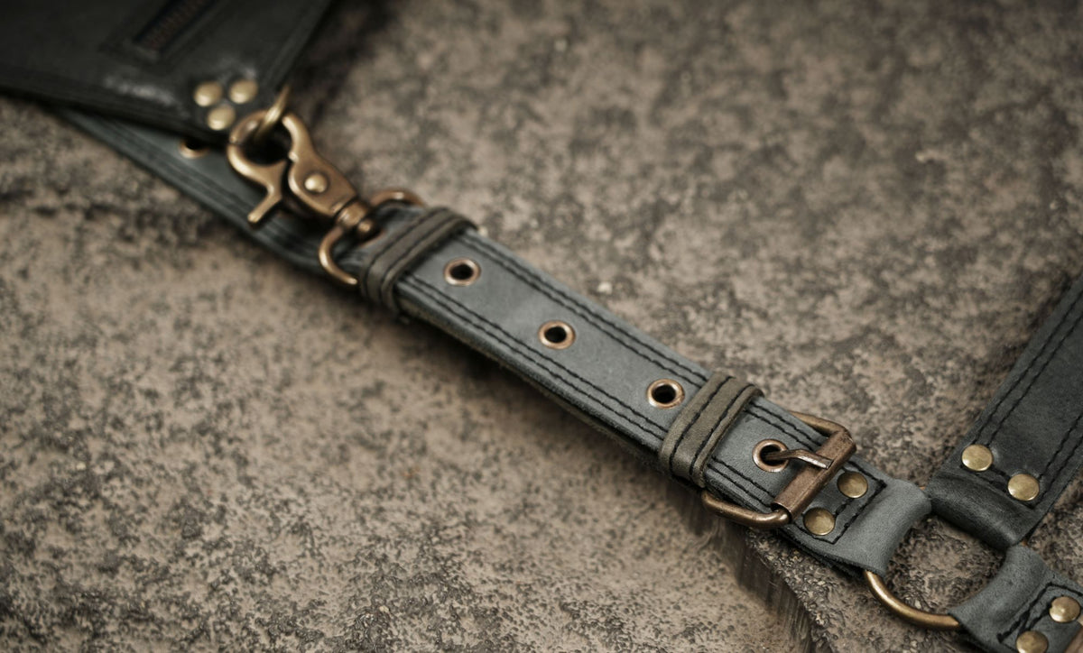 Black leather utility harness bag with antique metal hardware