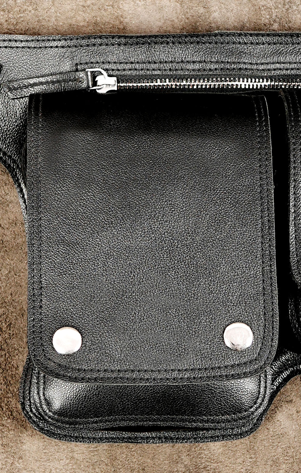 Adjustable leather hip bag with snap button pockets, flat lay