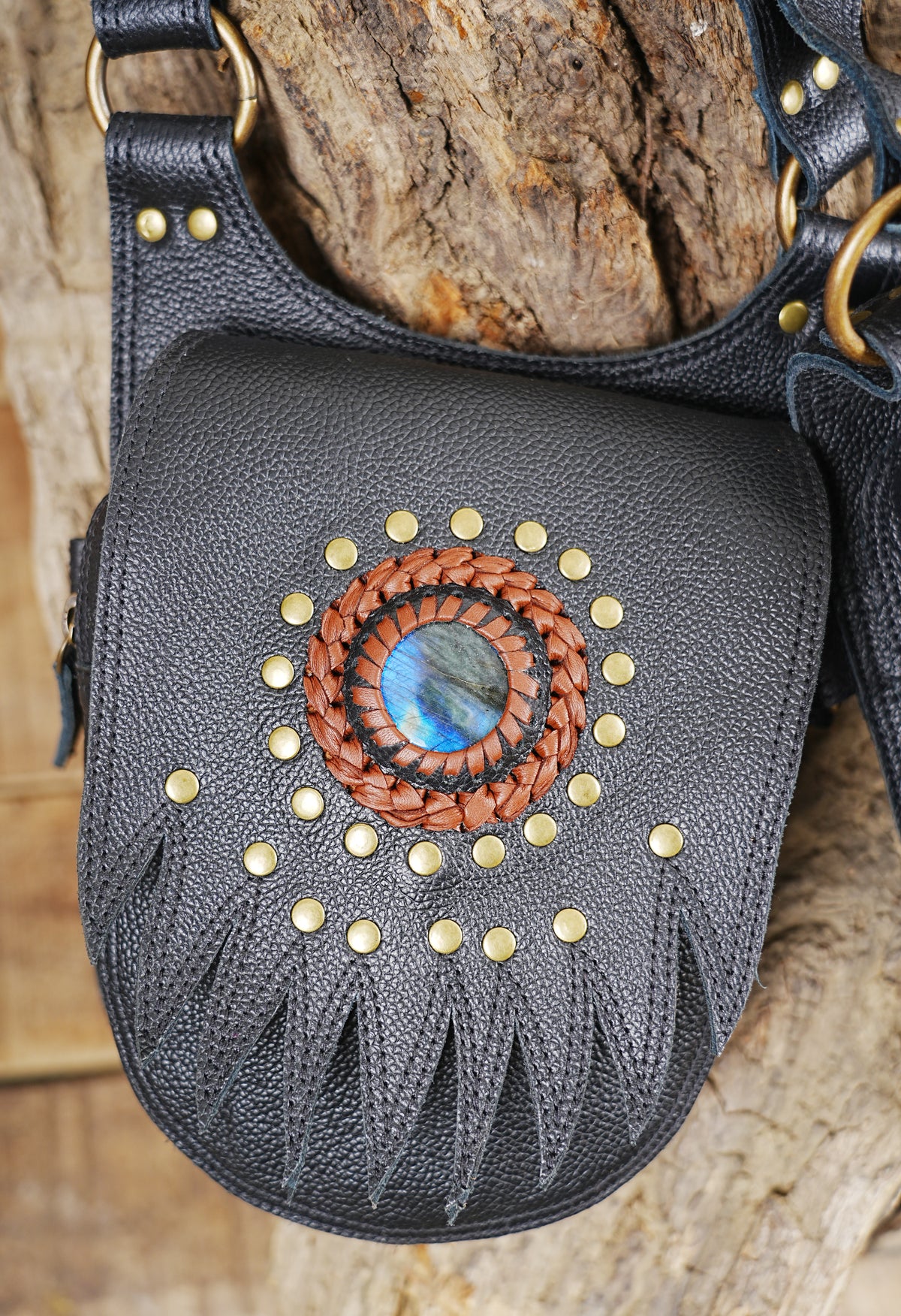 Black leather festival chest rig with studded pockets gemstone centerpiece and brass hardware