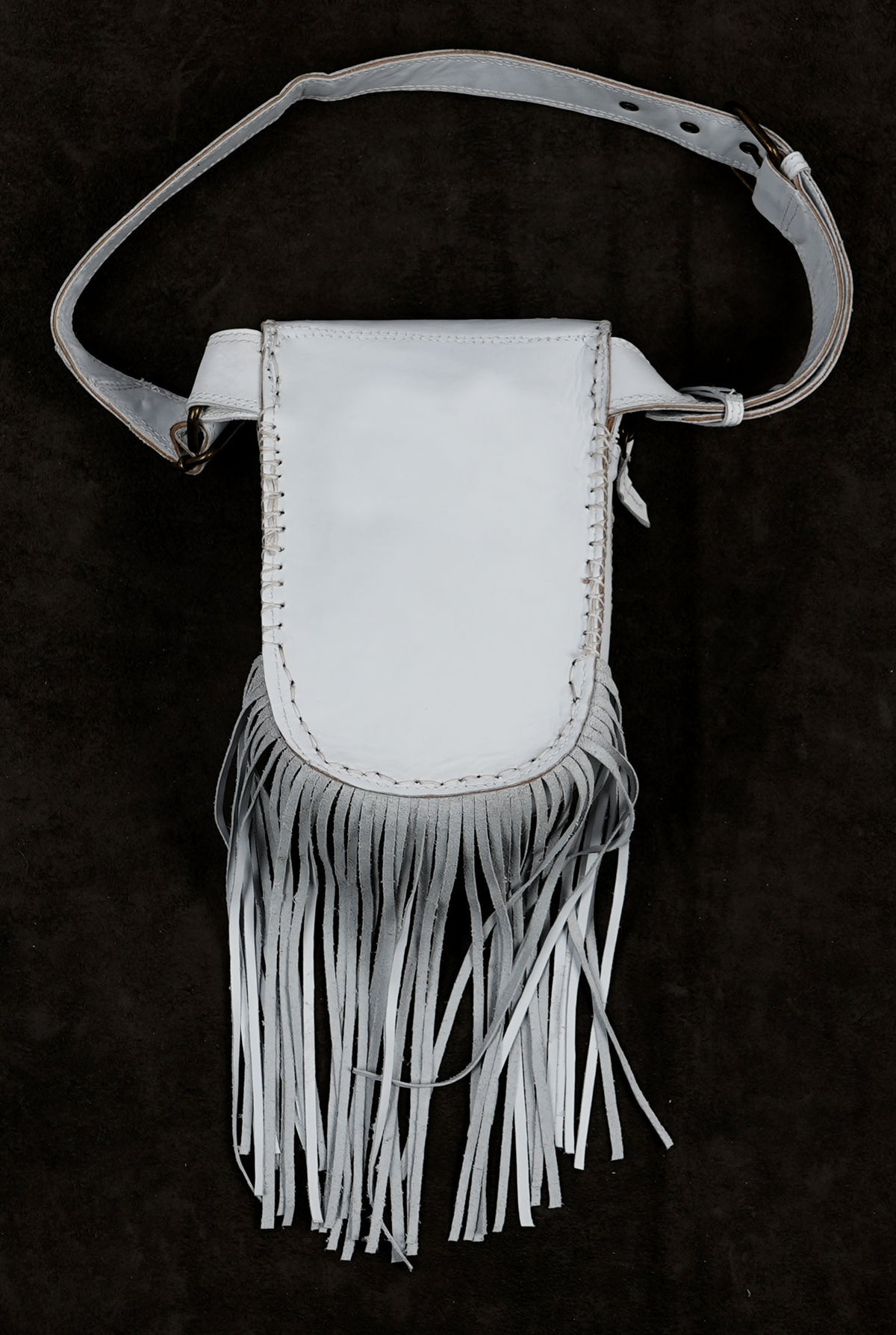 A white faux leather pouch bag with a long fringe bottom and an adjustable shoulder strap.