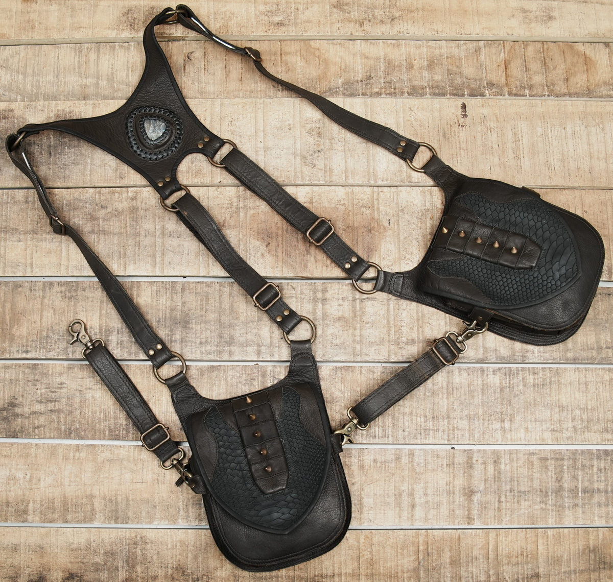 Artisan leather holster harness with stone centerpiece and detailed textured pocket flaps