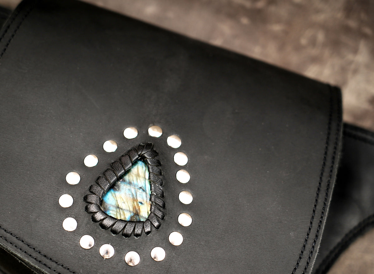 Black leather belt bag with studded teardrop stone, flat lay