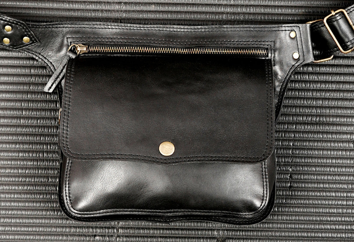 Black leather fanny pack with front zip pocket and brass hardware