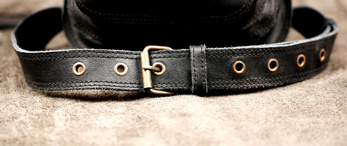 Black leather hip bag with brass studs and gemstone accent