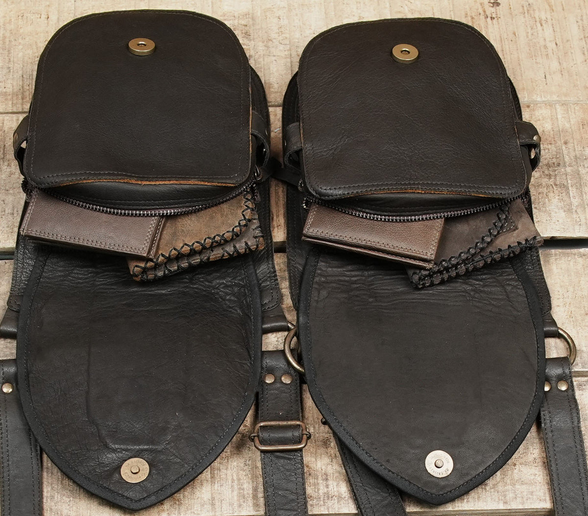 Textured black leather double pouch bag with adjustable straps and metal fittings