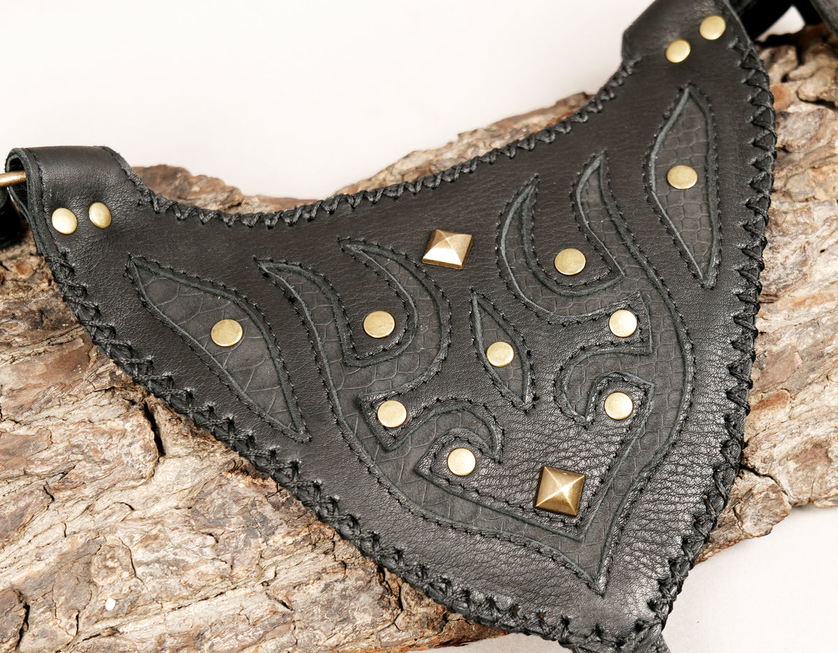 Black leather double thigh holster bag with decorative studded flaps and adjustable shoulder straps for festival wear.