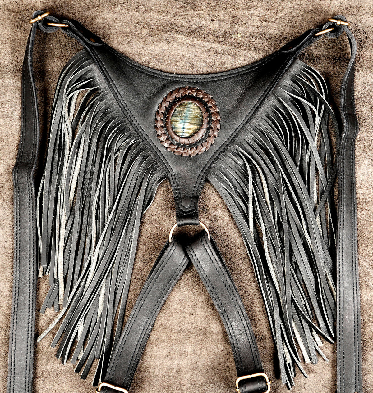 Dark aesthetic leather holster harness with fringe trim and stone-embellished utility pouches.