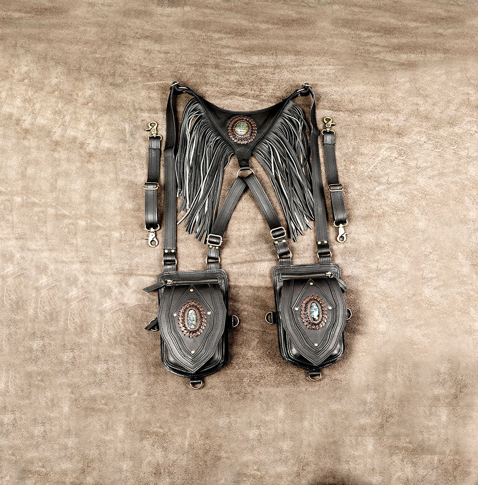 Multi-strap black leather utility holster bag with fringe trim, brass buckle fasteners, and dual pouches.

