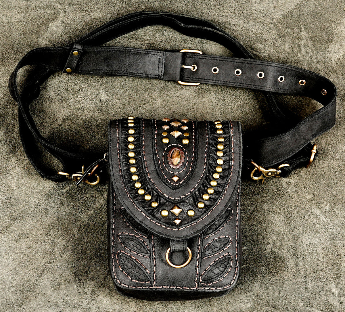 Black leather hip bag with brass studs and gemstone inlay on adjustable belt.   