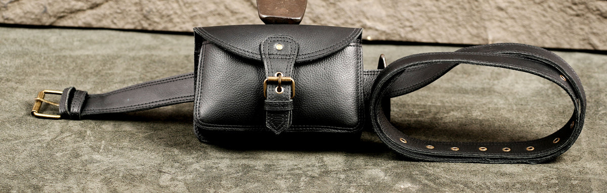 Black leather waist pouch with antique brass hardware and stitched edges