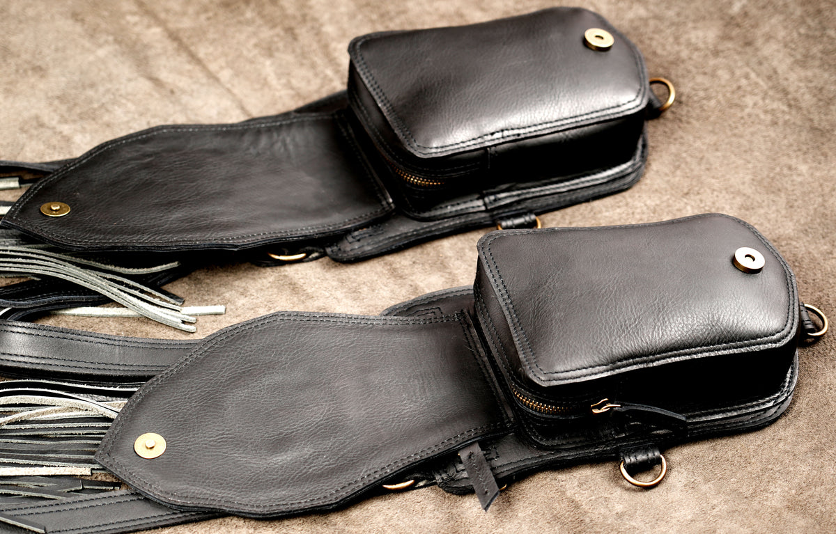 Gothic black leather shoulder holster with fringe accents and ornate gemstone centerpiece medallions.