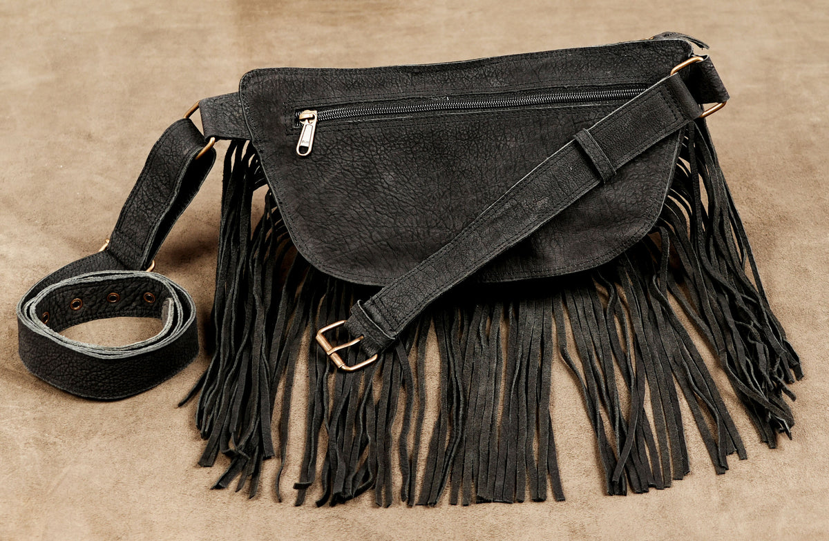 Edgy black hip bag with long fringe and white snake applique for rave festivals.
