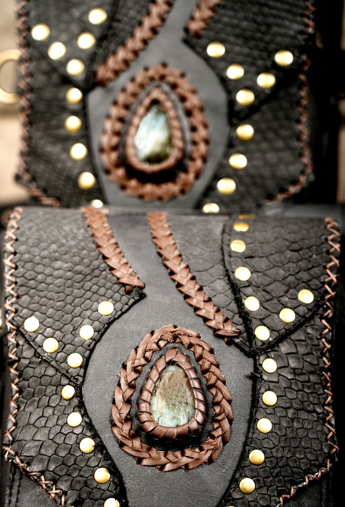 Handmade black leather festival bag with studded panels and adjustable shoulder straps