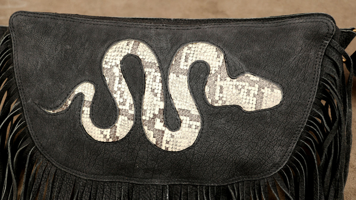 Black Burning Man belt bag with fringe details and snake pattern for desert festival wear.

