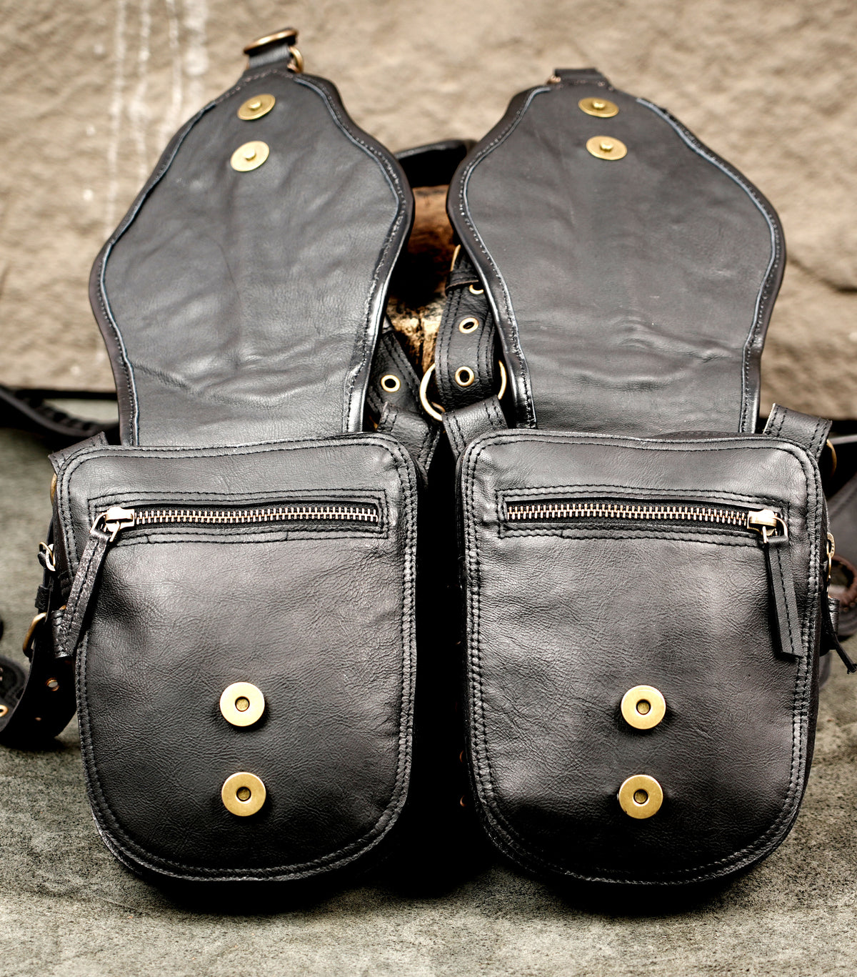 Black leather costume harness with twin utility pouches and detailed braided accents
 