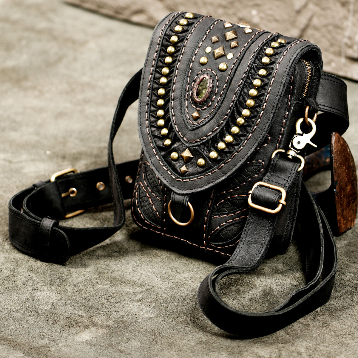 Studded black leather waist pouch with adjustable strap and brass hardware