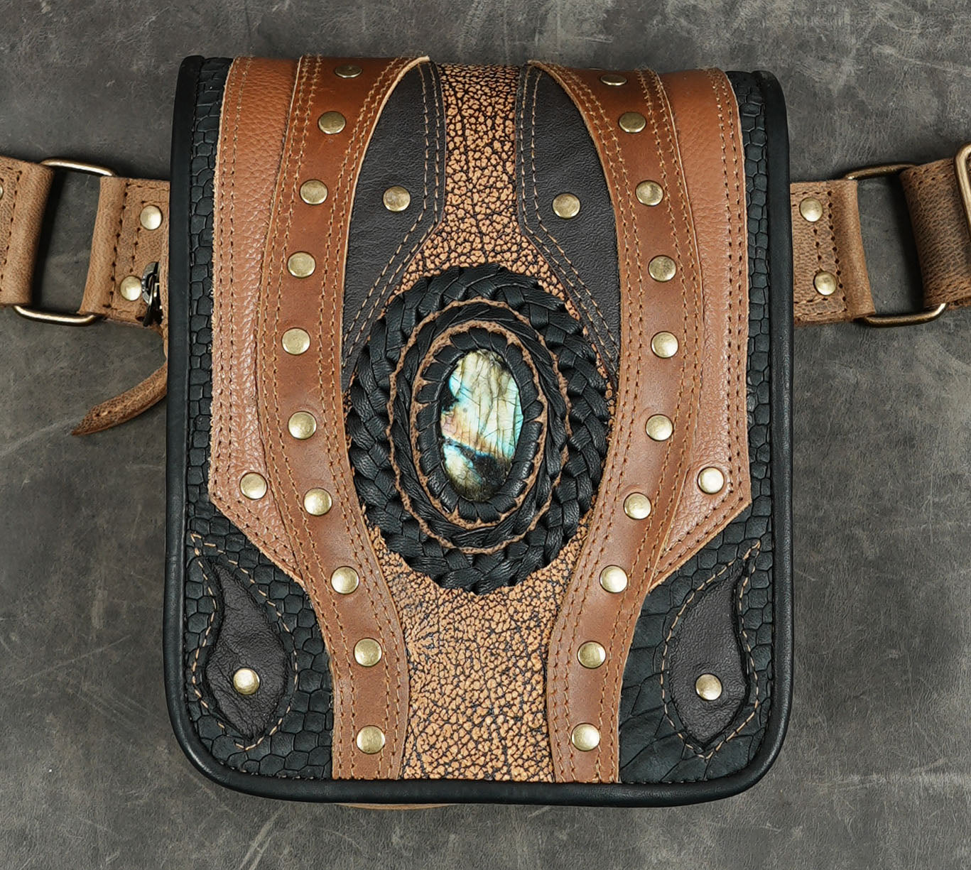 Braided leather waist bag with studded seams, flat lay view