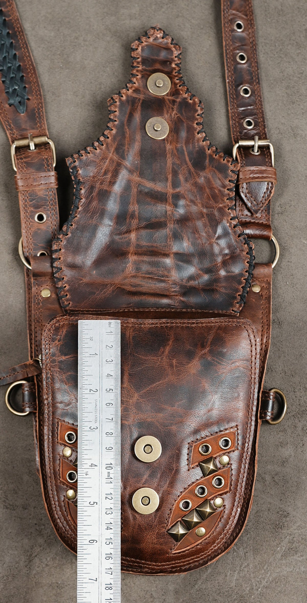 Steampunk costume accessory featuring a brown leather harness and twin utility bags