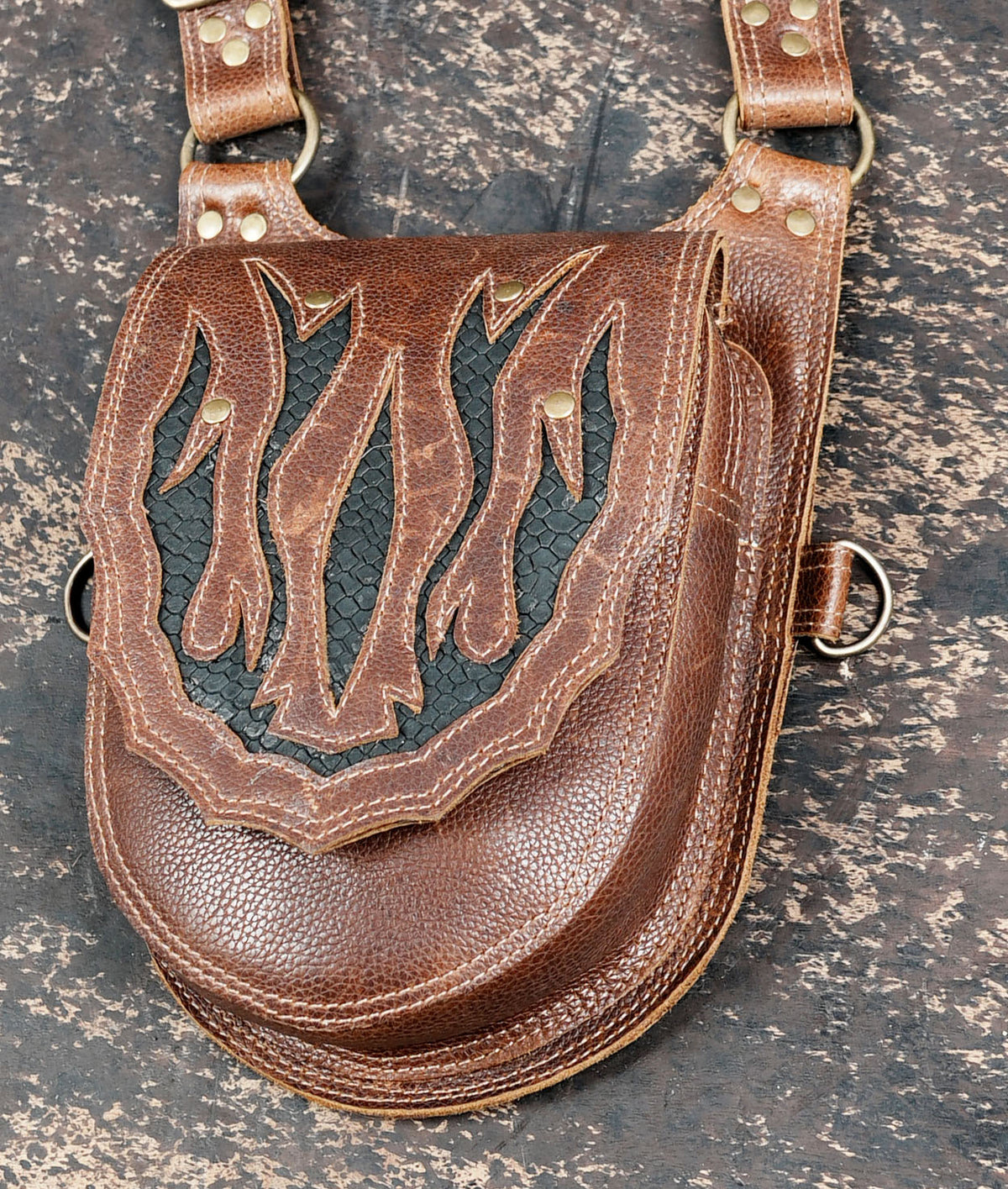 Brown double pouch thigh holster with decorative flame patterns and adjustable straps