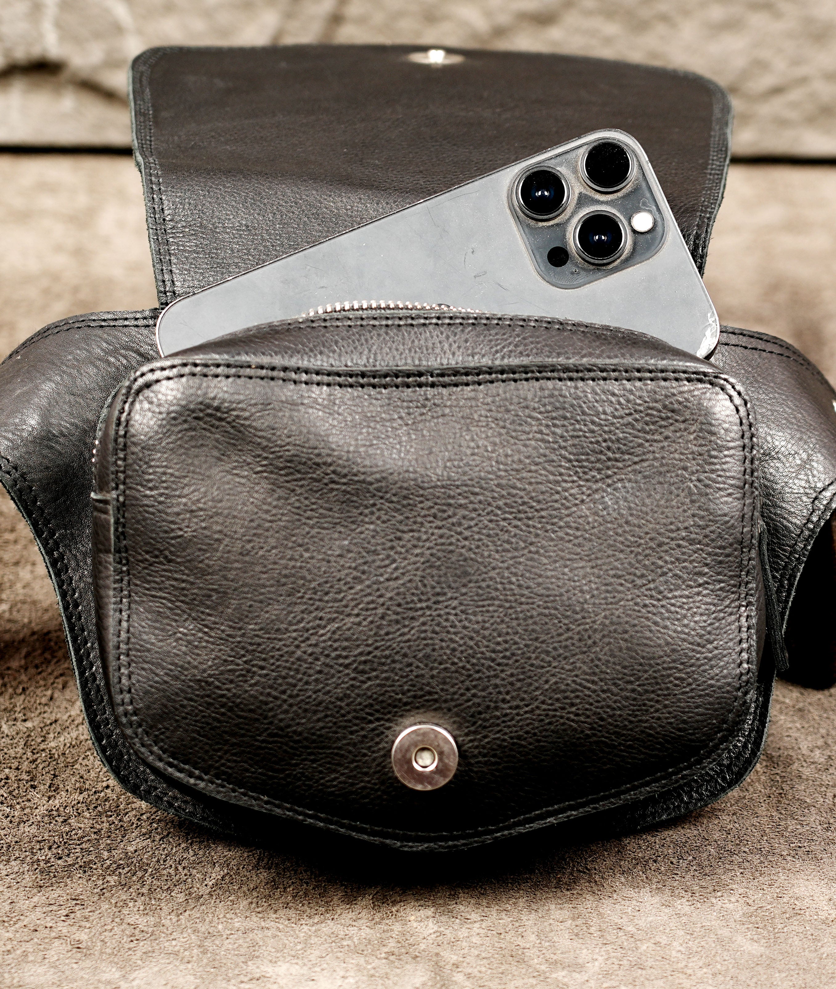 Clean leather hip bag with pointed flap, full flat lay view