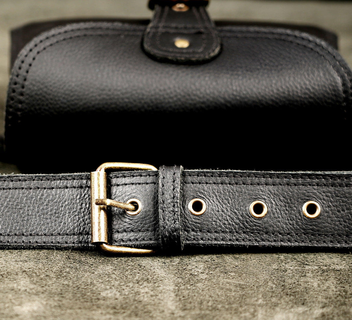 Black leather bum bag with buckle flap closure and pebble grain finish