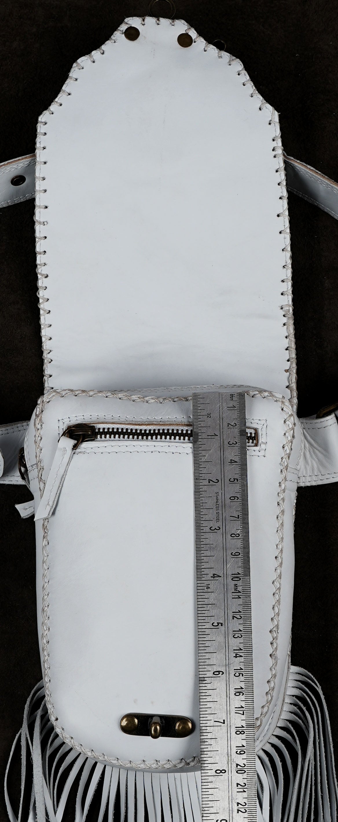 A white leather fringe pouch with a zipper pocket, shown open with a metal ruler placed vertically inside to indicate size.