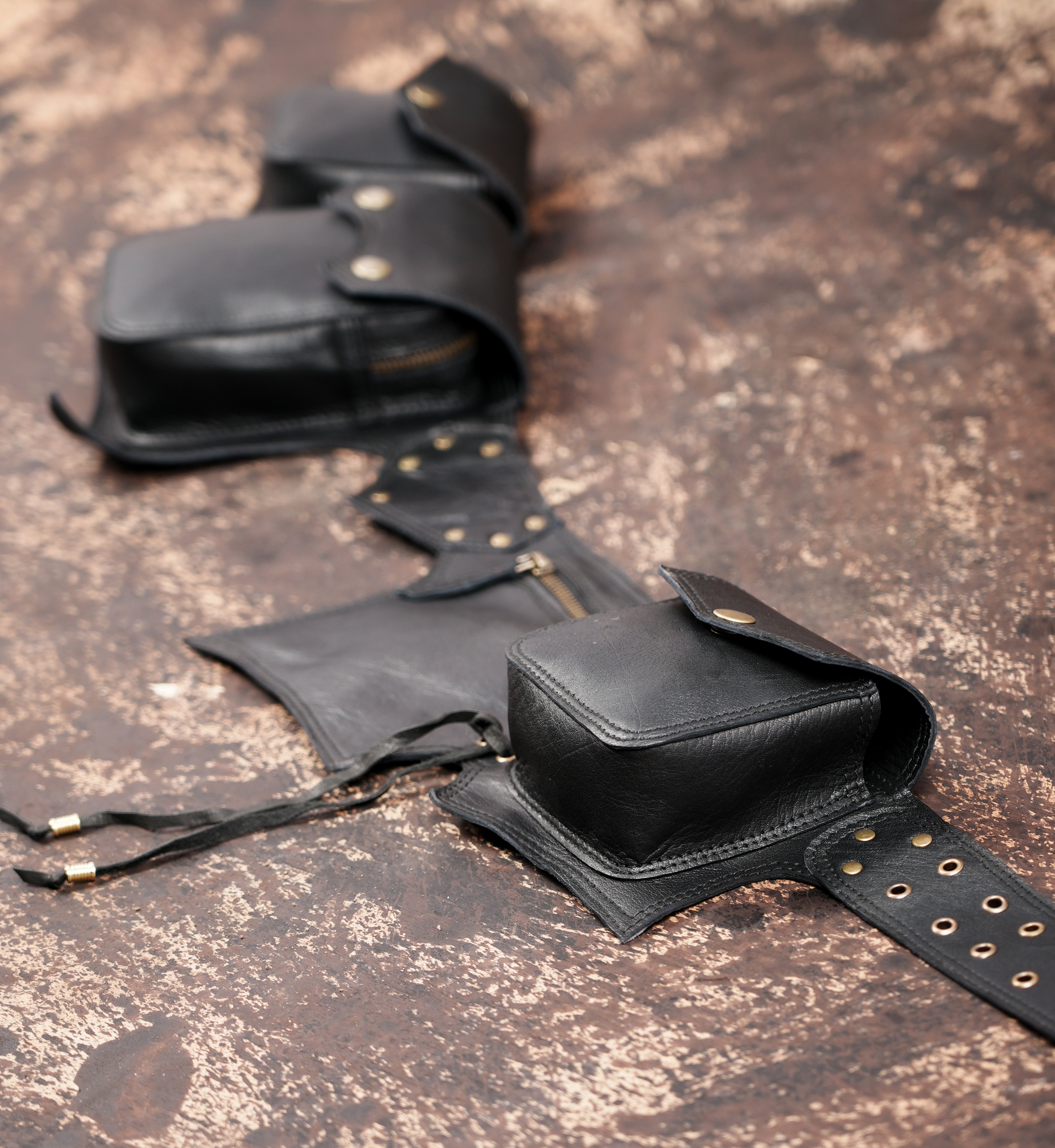 Adjustable black leather belt with zipper and snap pouches
