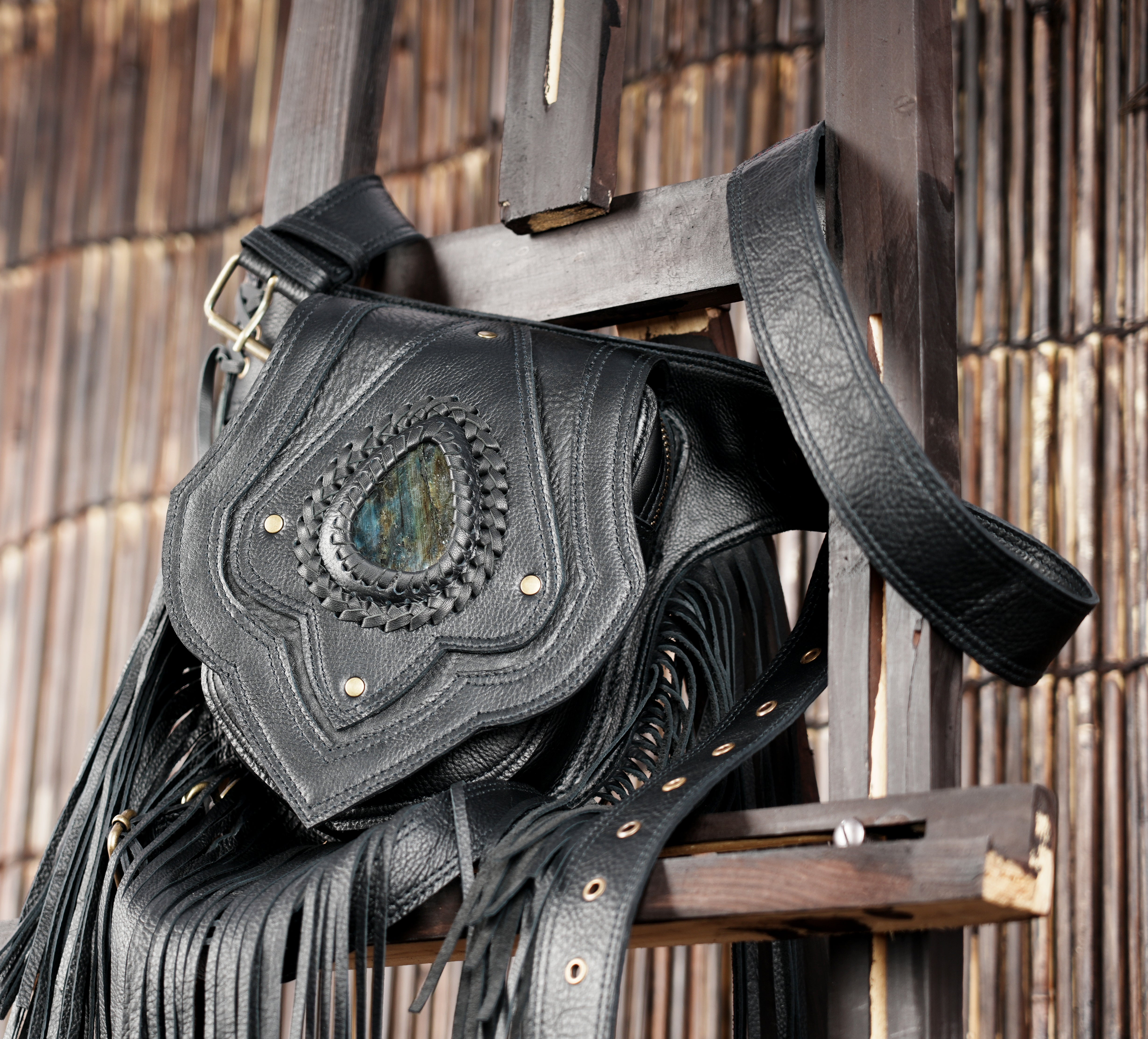 Black leather belt bag with fringe and handcrafted stone design