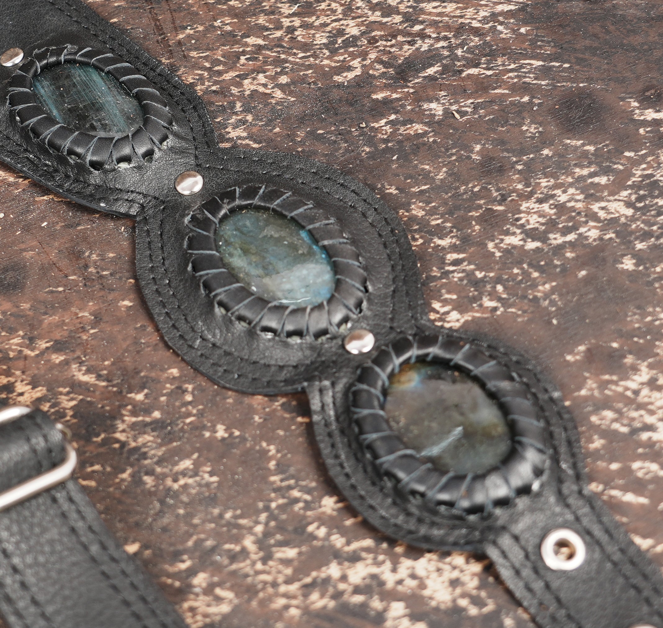 Custom leather holster harness featuring geometric tooling and stone detail