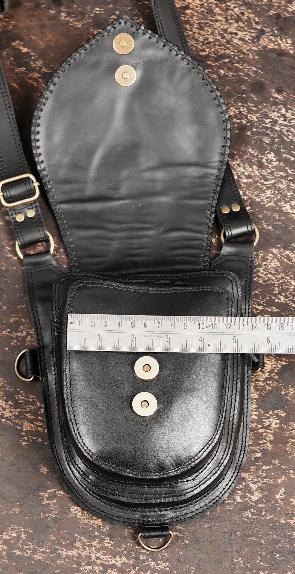 Black leather crossbody holster bag with detailed stitching