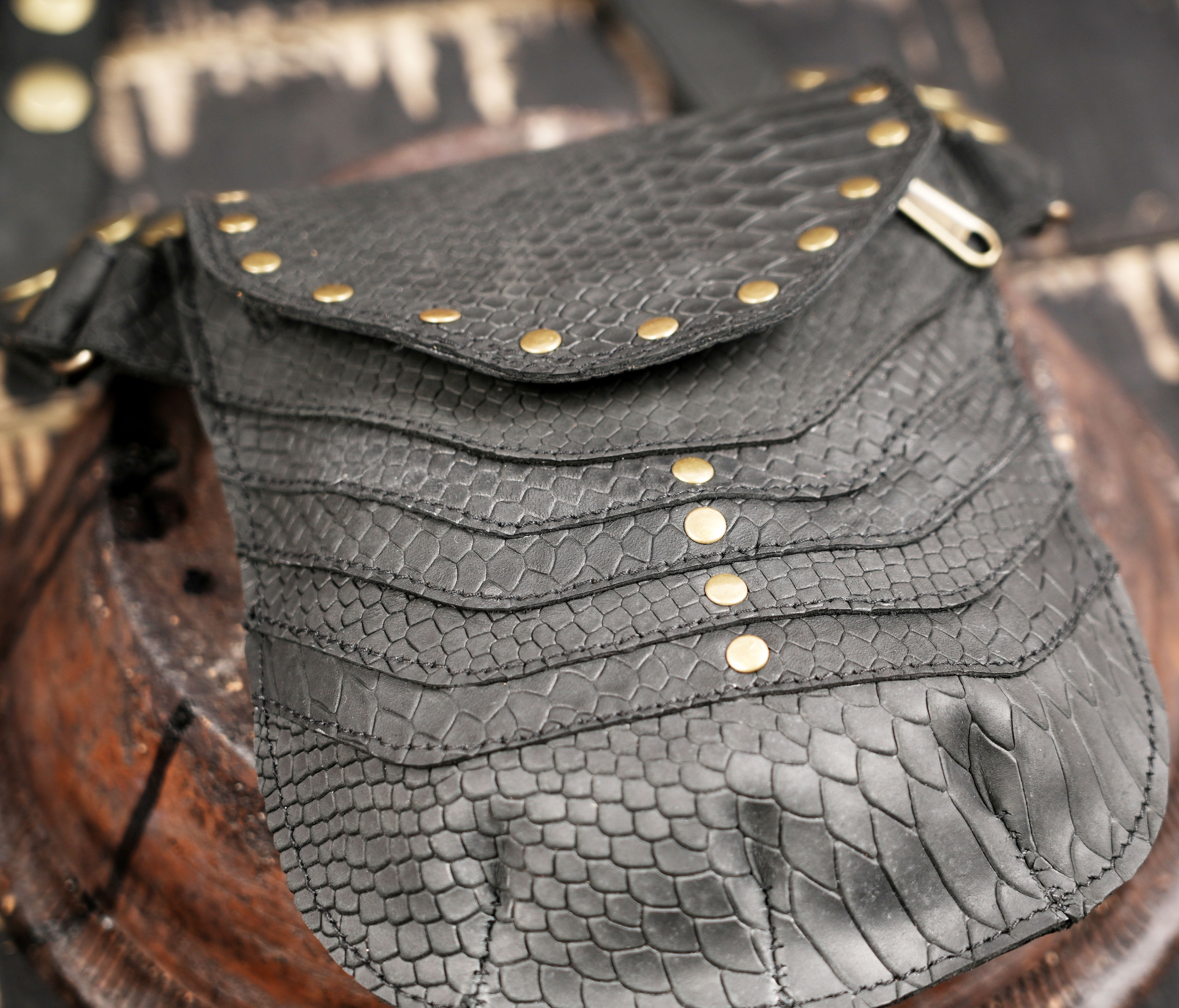 Black leather crossbody holster featuring two front pockets and antique brass hardware