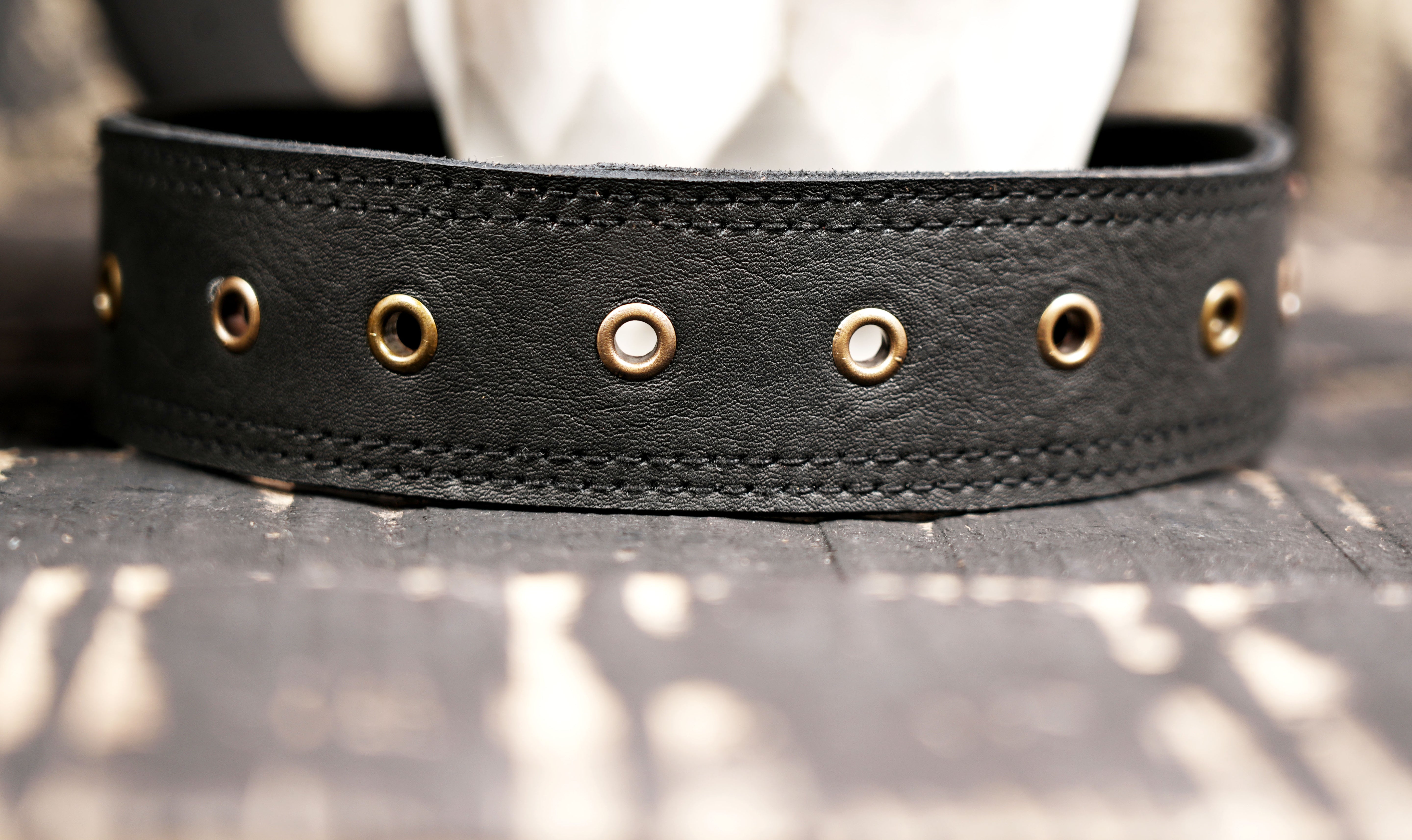 Black leather thigh bag belt with strong stitching and rivets