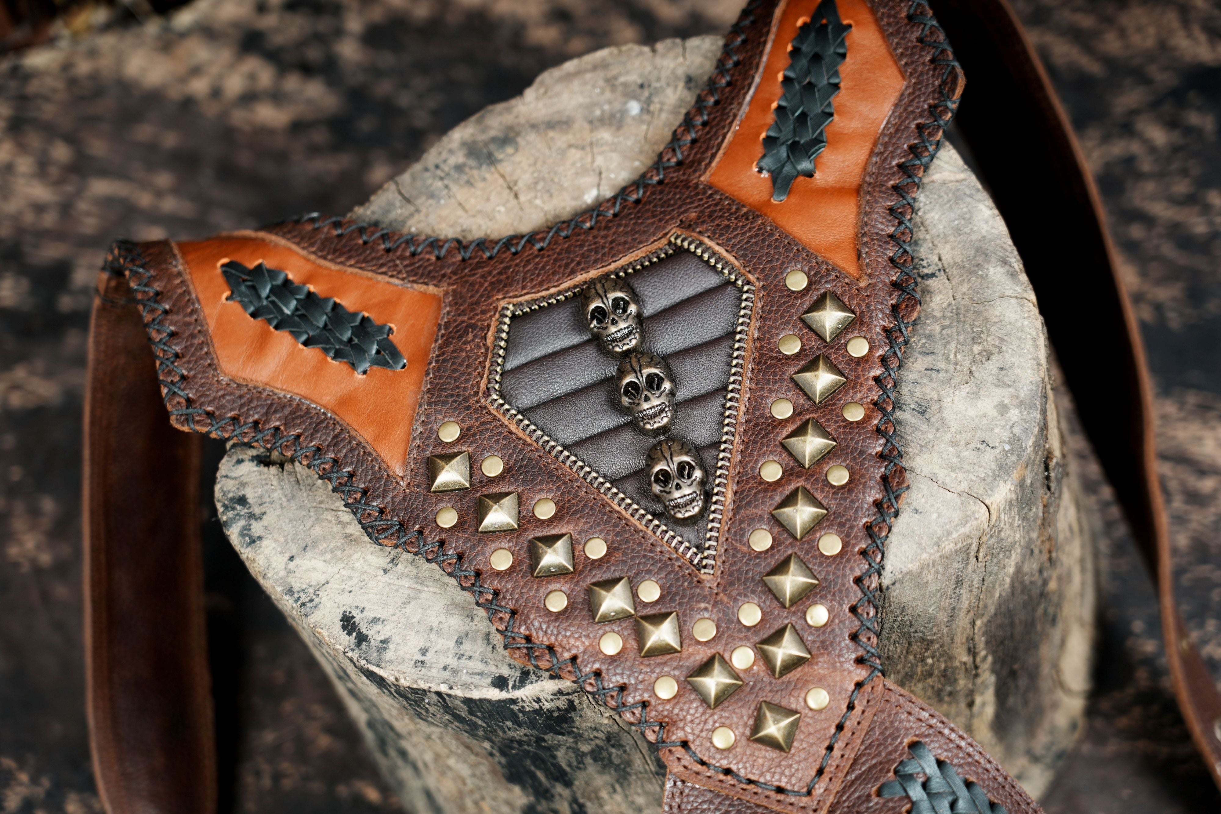 Handcrafted leather chest holster with skull accents and braided design