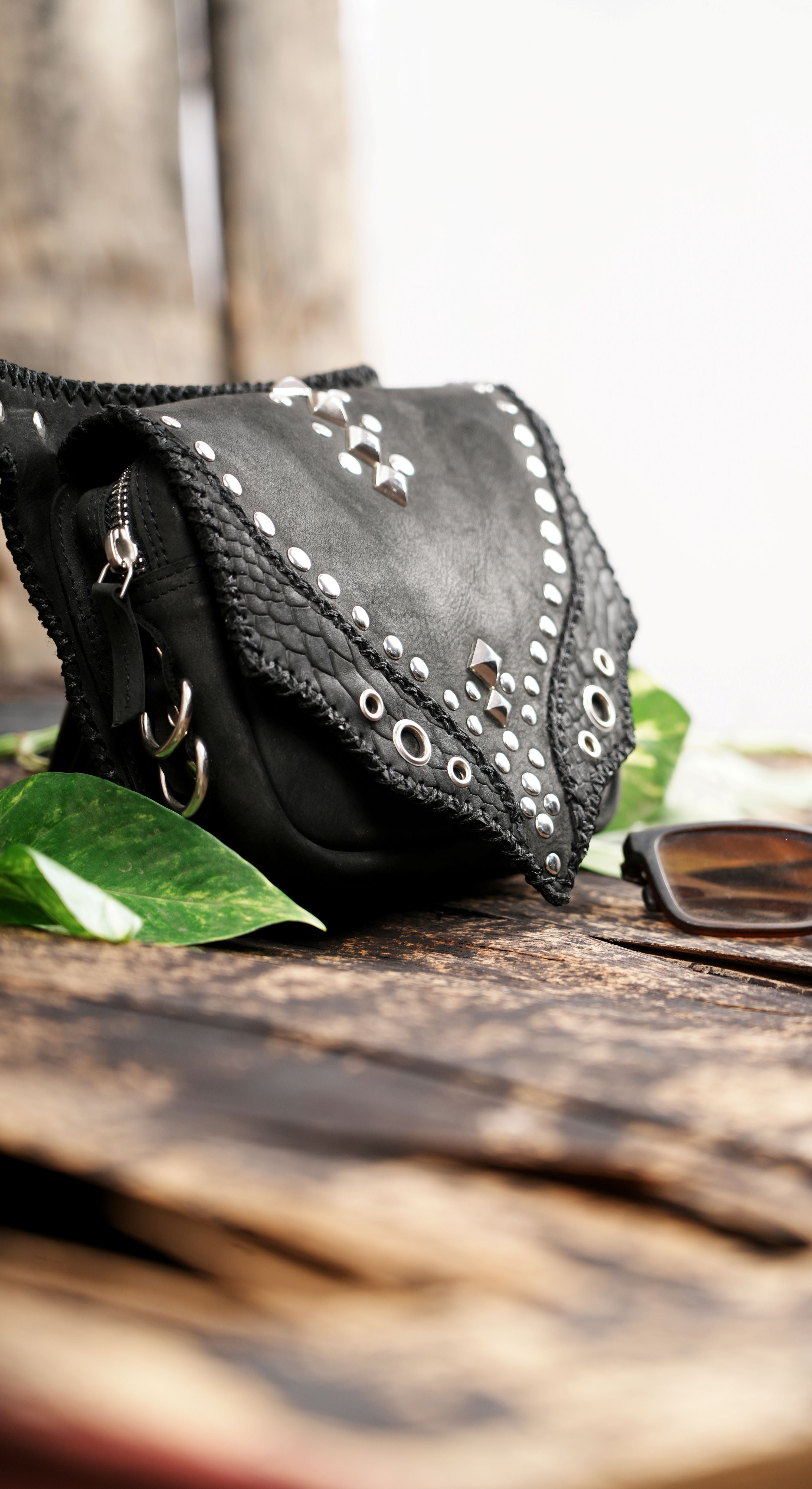 "Handcrafted leather waist bag with snakeskin-style accents"