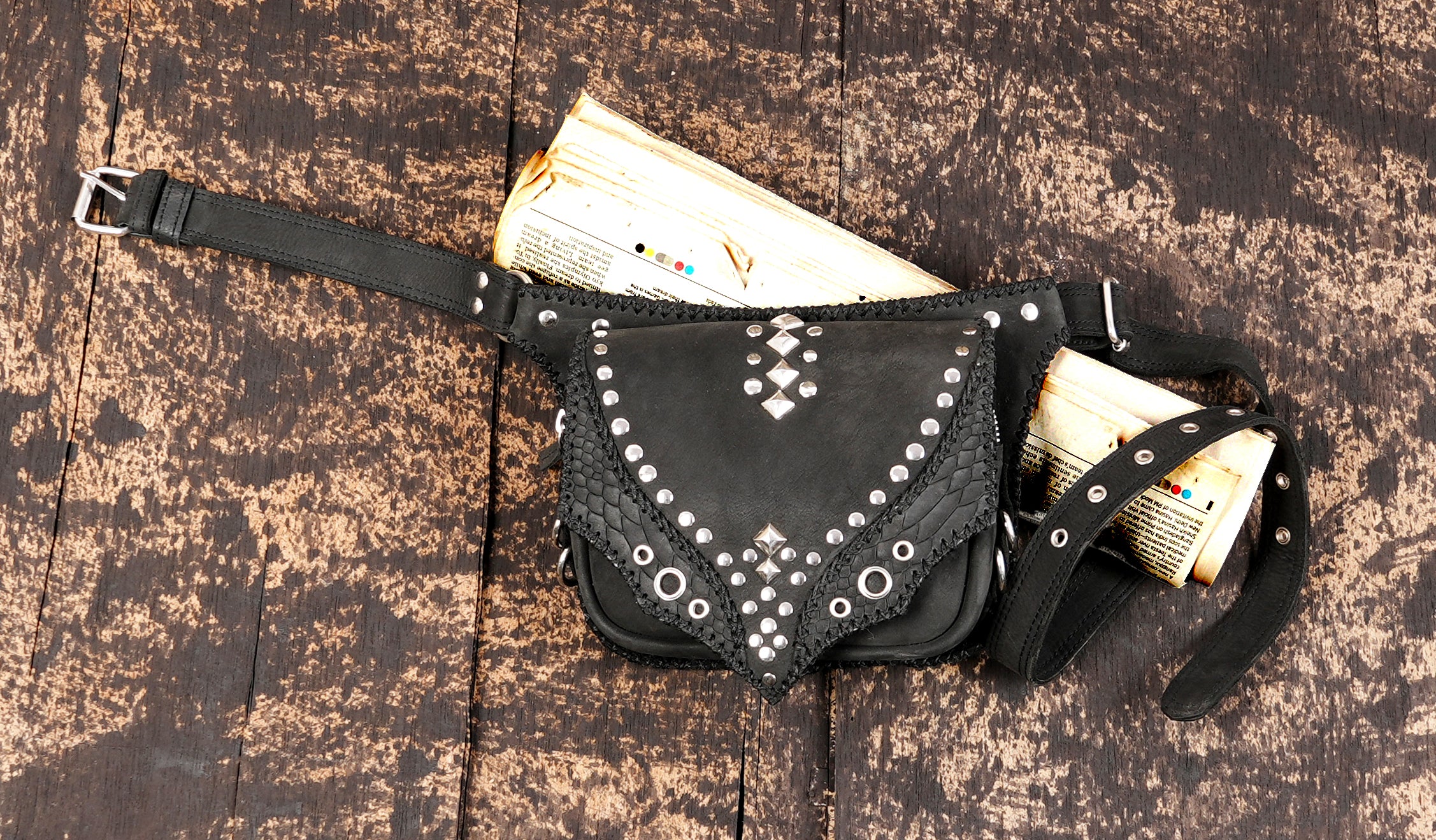 "Black leather fanny-style belt bag with stud accents"