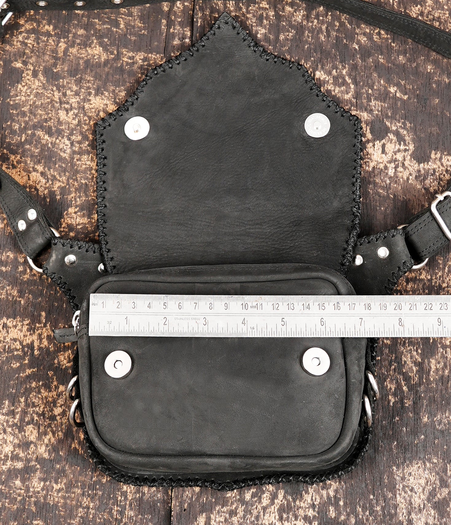 "Black leather travel waist pouch with secure studded flap"