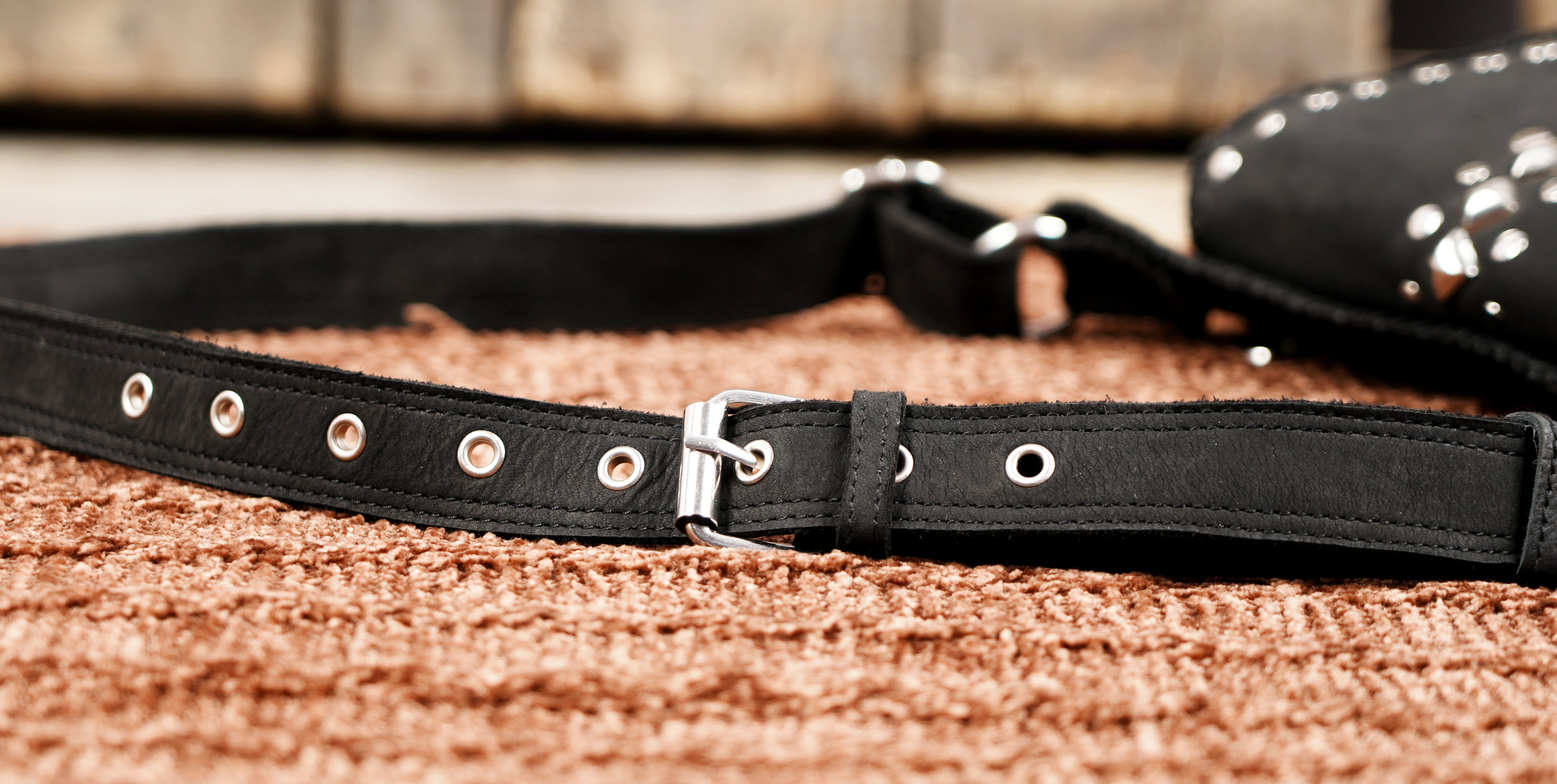 "Edgy black leather hip pouch with studded front flap"