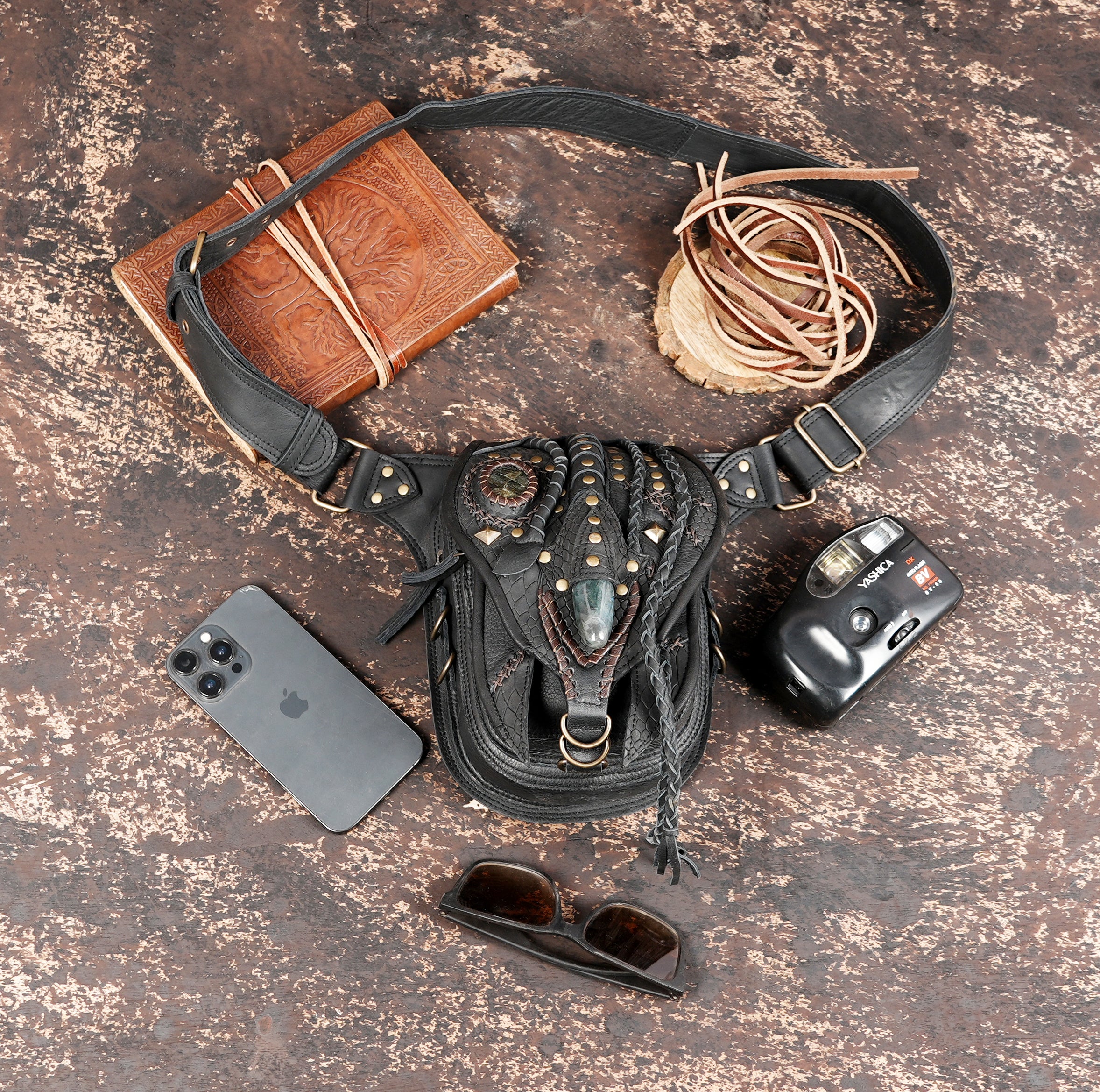 "Hand-tooled leather belt bag with rustic brass rivets"