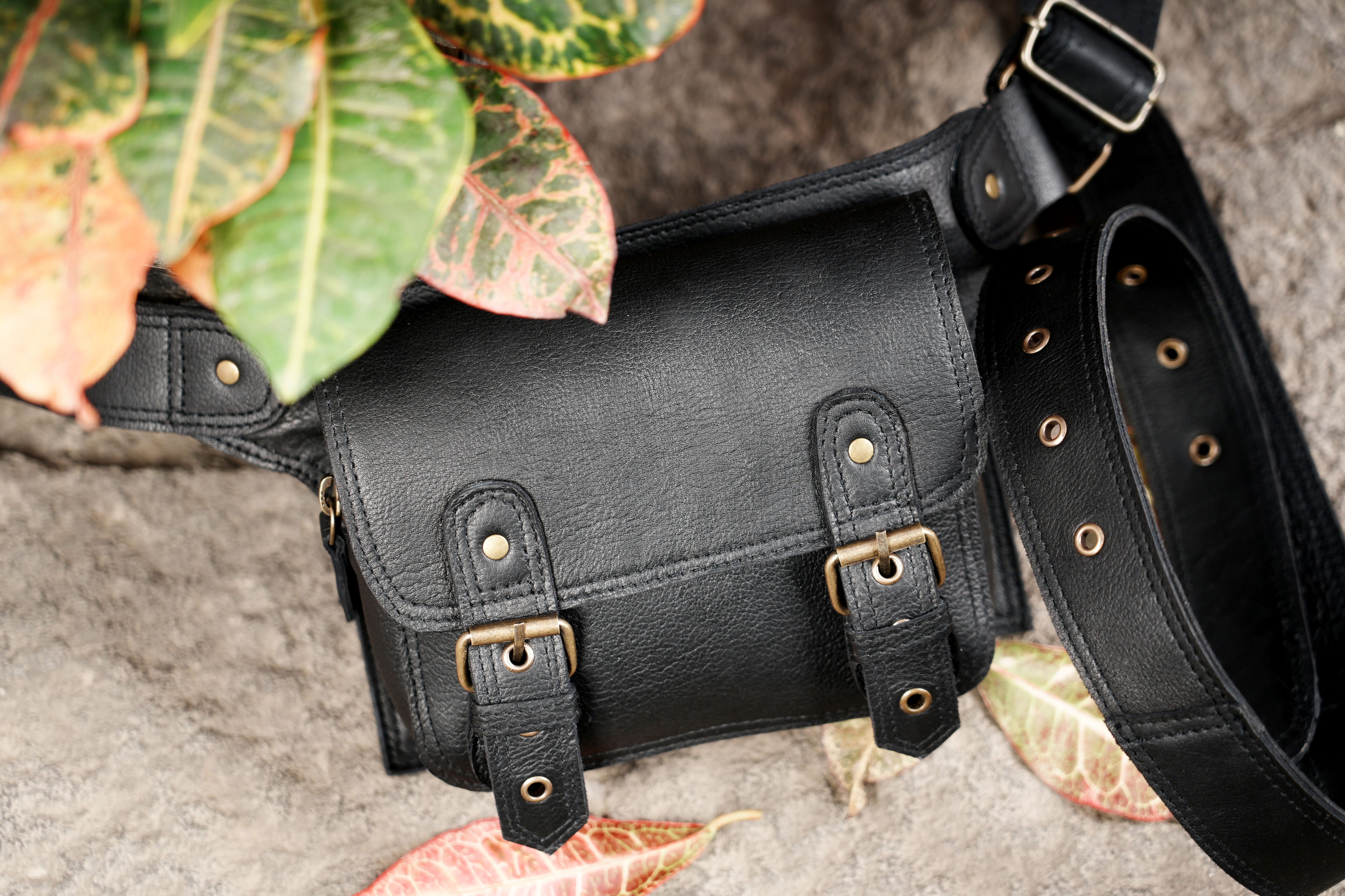 "Minimalist black leather hip pouch for travel and festivals"