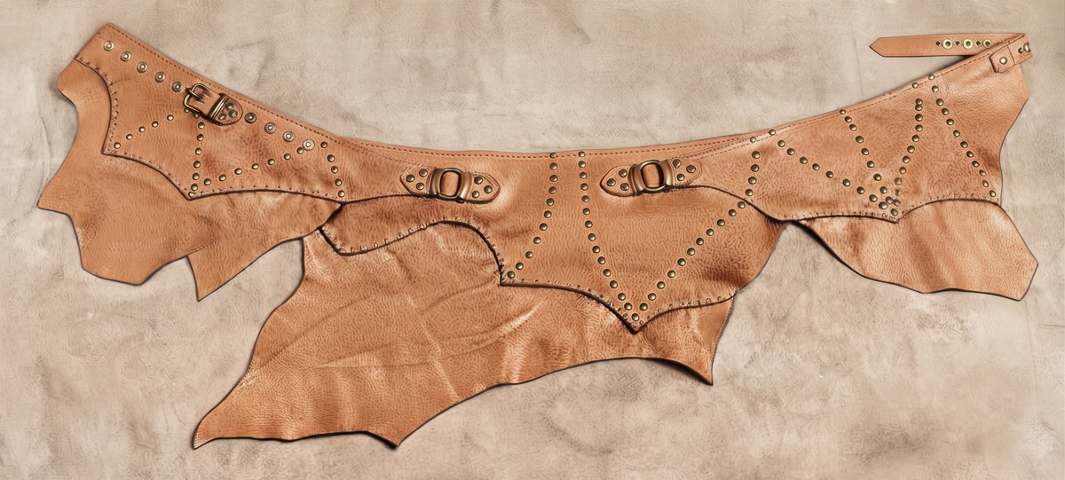 Studded leather hip skirt with asymmetrical edges and handcrafted black stitching