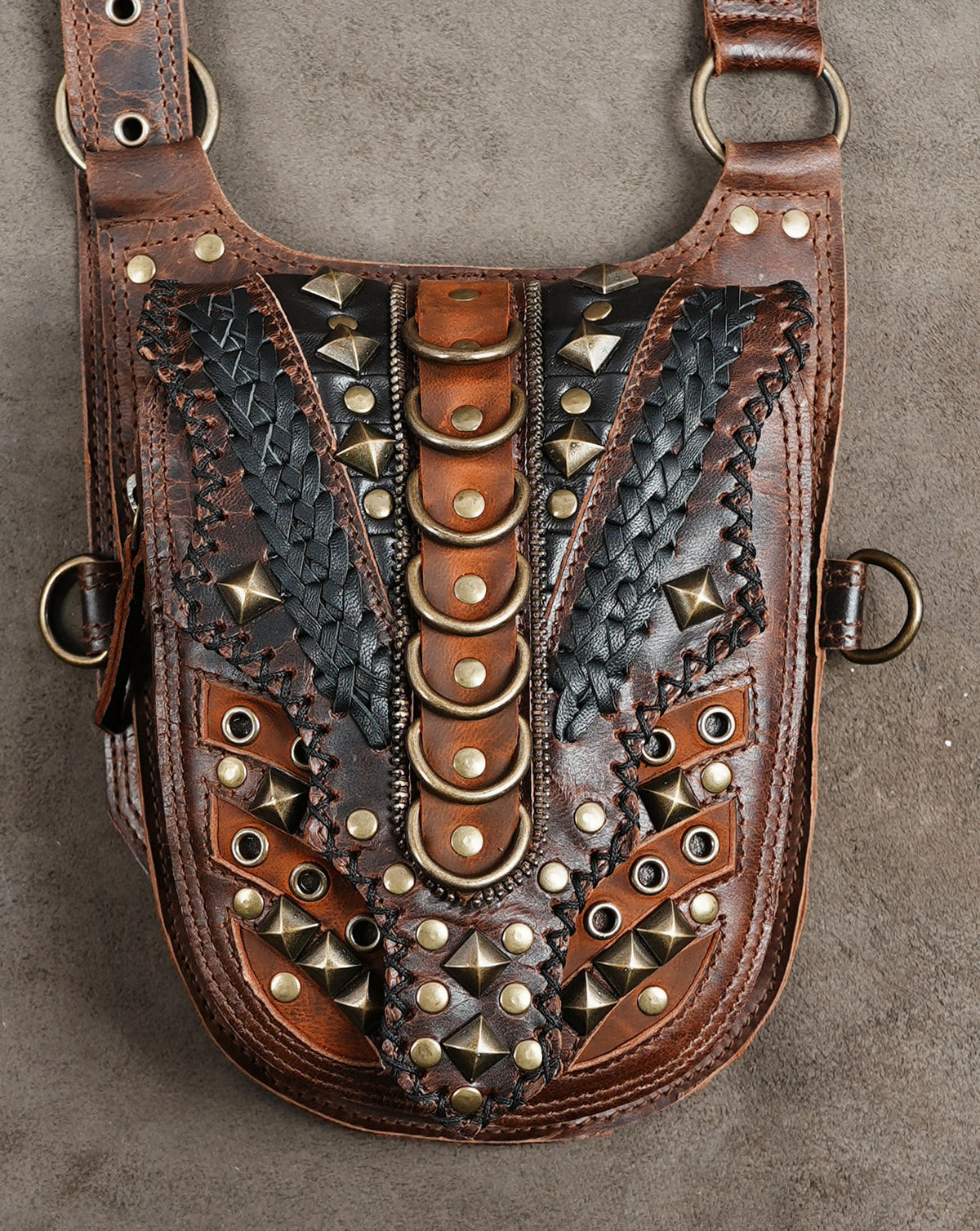 Brown leather shoulder holster harness with two studded utility pouches and antique brass hardware