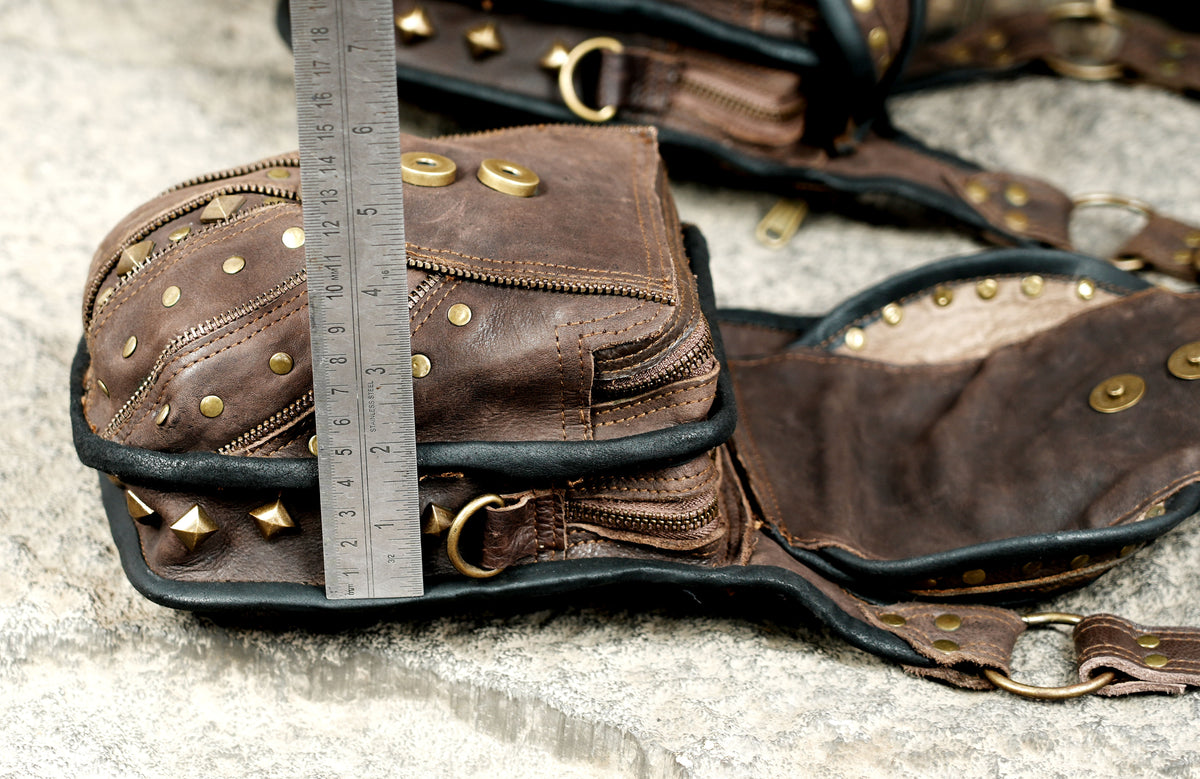 Unisex boho leather harness bag with two utility pockets and antique brass-style hardware