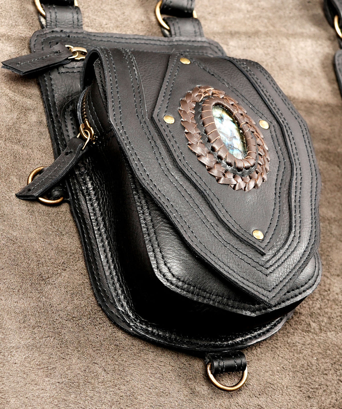 Black leather undercover shoulder bag harness with twin utility pouches for travel and outdoor events.