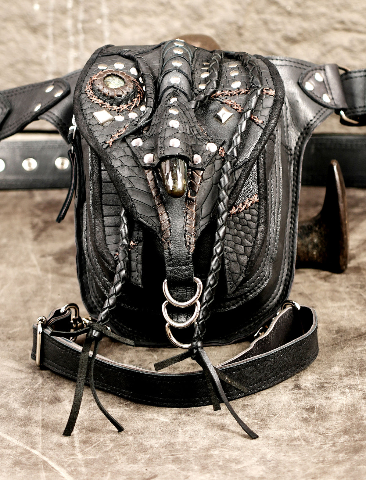 Festival-ready black leather drop-leg pouch with carved stone decor