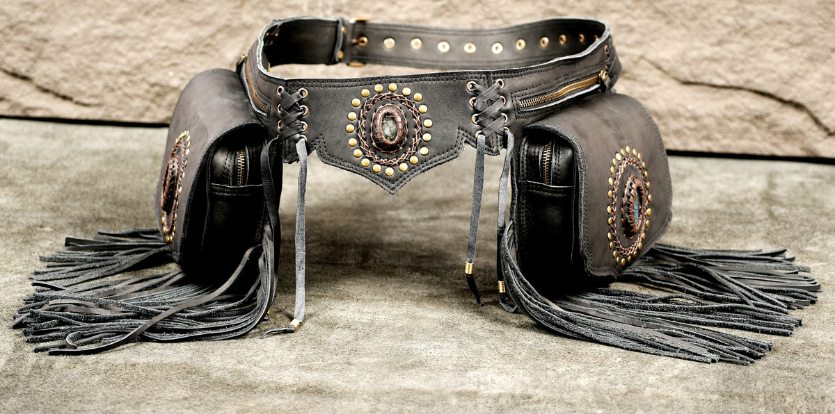 Black leather chaps belt with matching pouches, featuring gold-tone studs, silver-tone laces, and dark gray fringe tassels.