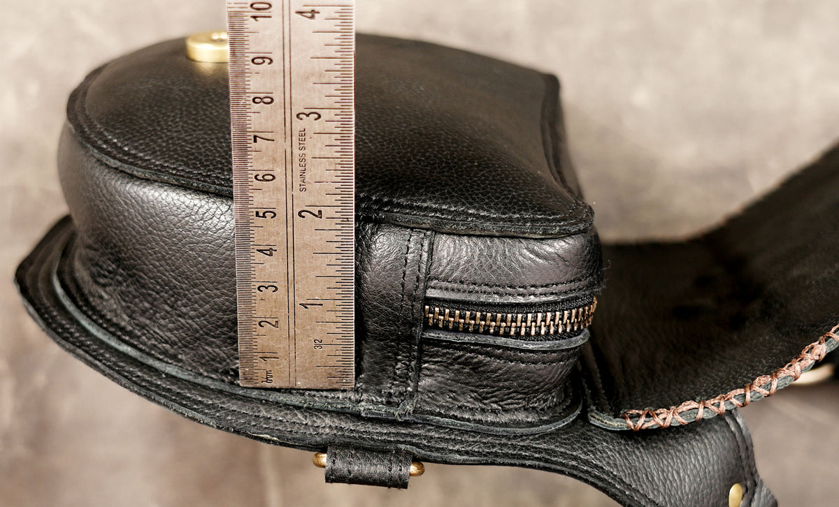 Artisan black leather harness with studded panels and textured detailing