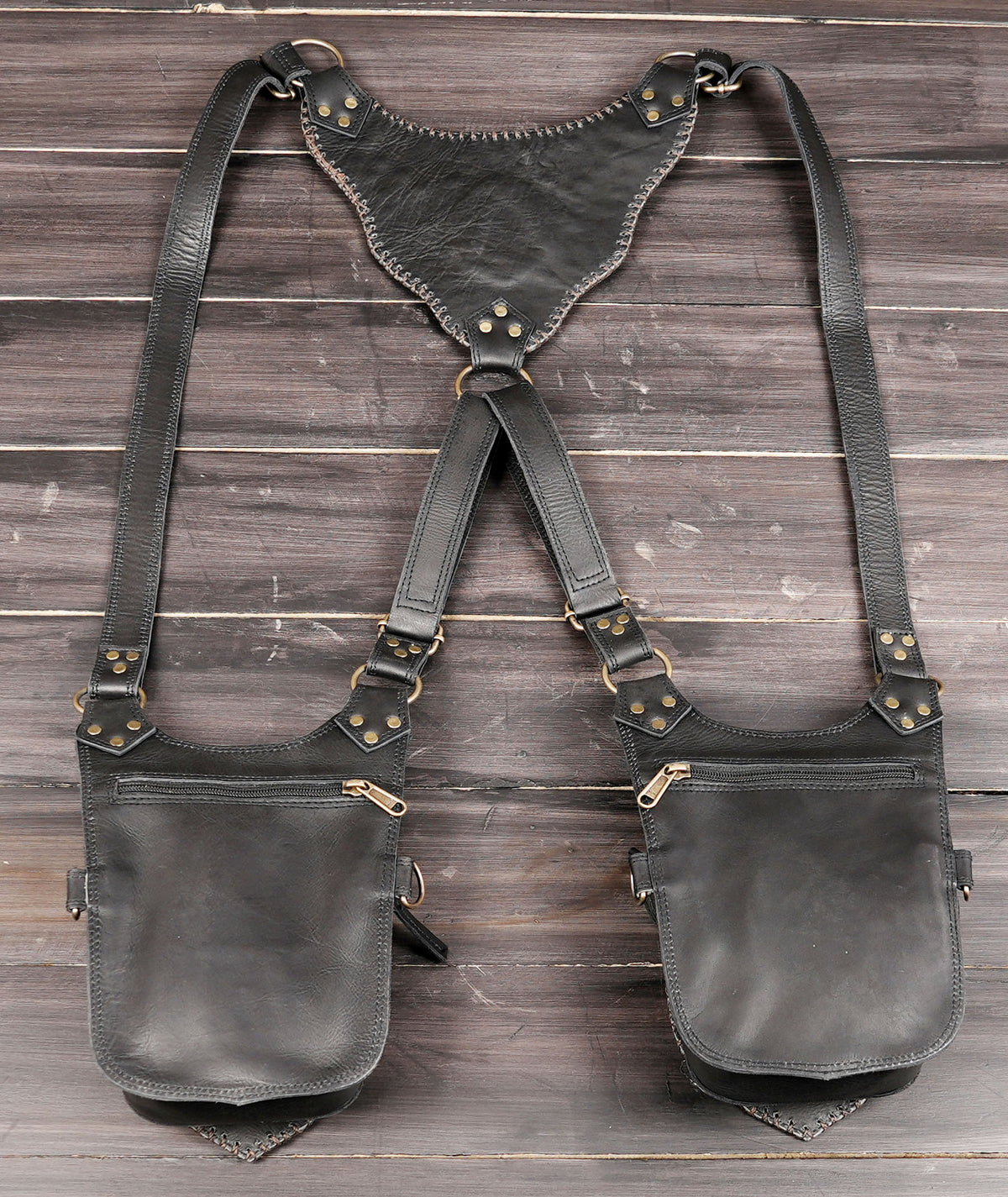 Handmade black leather hip bags with brown whip stitching and brass-tone studs
 
