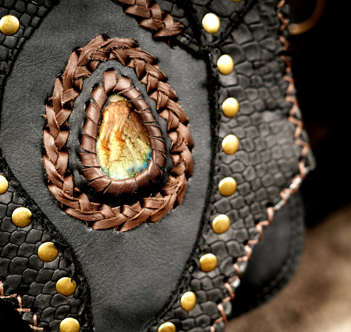 Black leather festival harness bag with braided brown leather details and metal studs